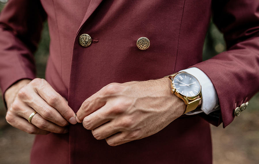 Close-up of man wearing a suit and golden watch buttoning his jacket Photograph by Westend61