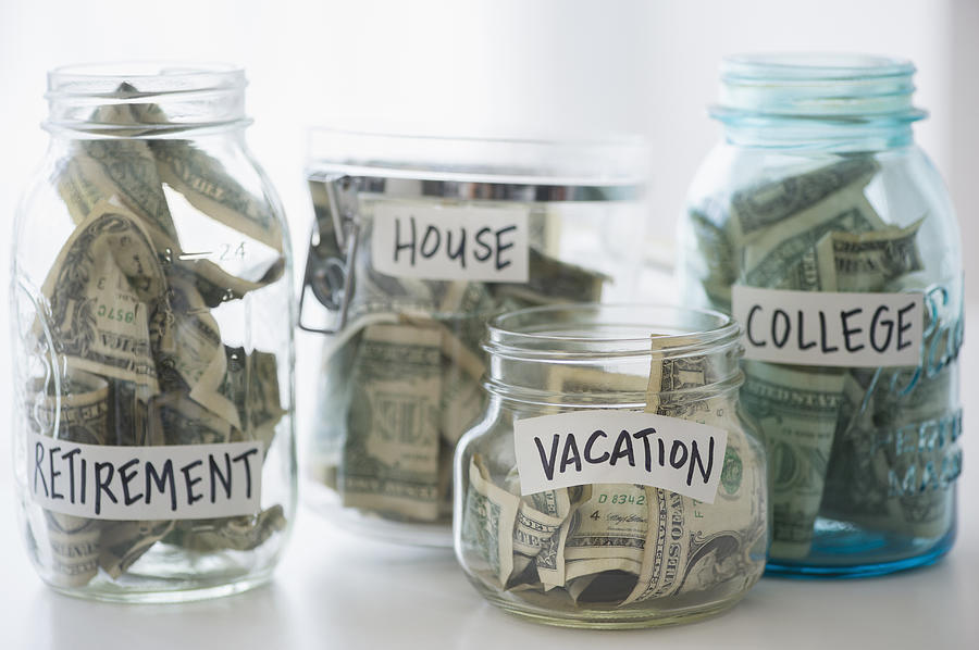 Close up of savings jars with money Photograph by JGI/Jamie Grill