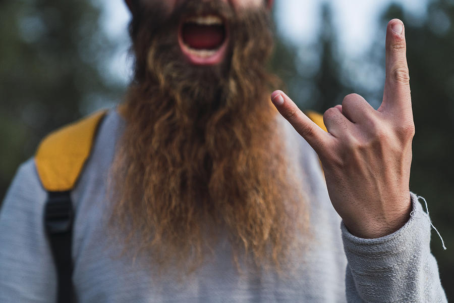 Close-up of screaming man with beard making horn sign Photograph by Westend61