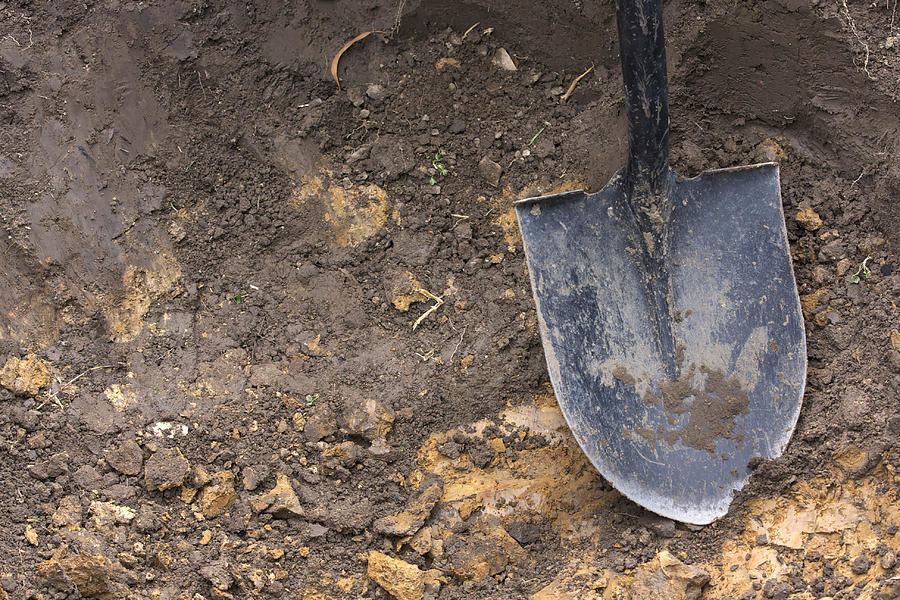 Close-up of spade shovel being used to dig a hole in soil Photograph by MoMorad