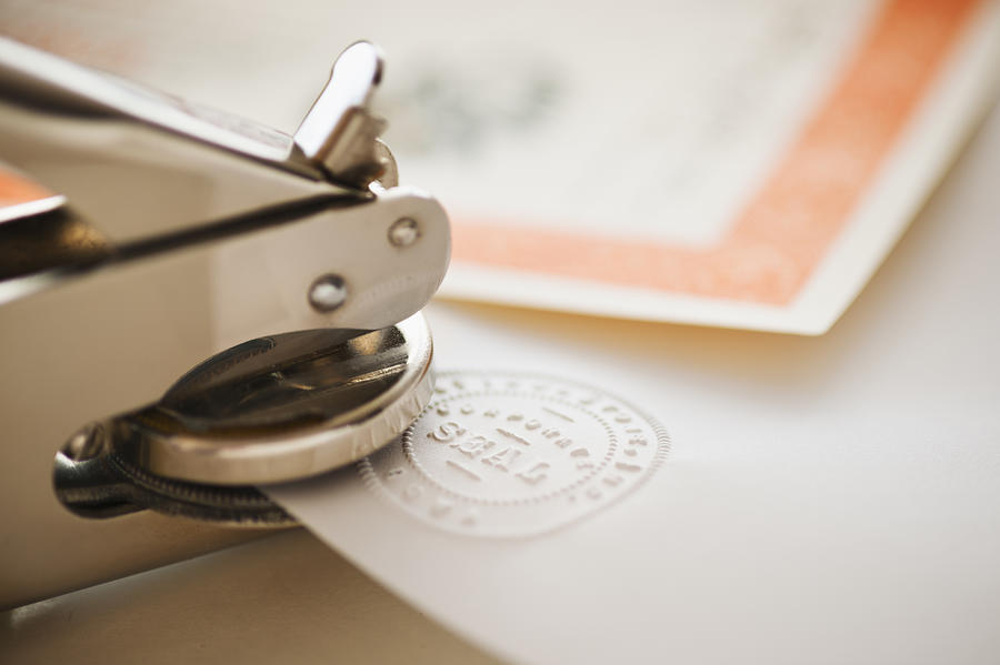 Close up of stamper making seal on paper Photograph by Tetra Images