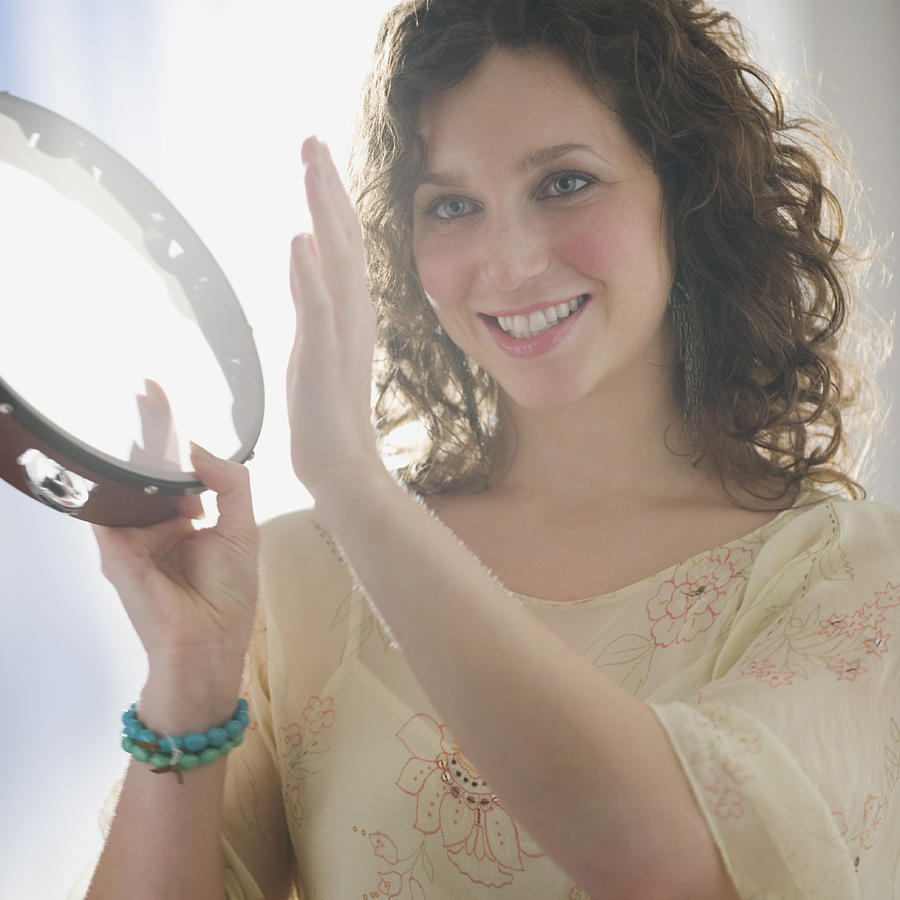 Close up of woman playing tambourine Photograph by Tetra Images