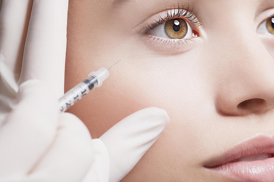 Close up of woman receiving botox injection under eye Photograph by Robert Daly