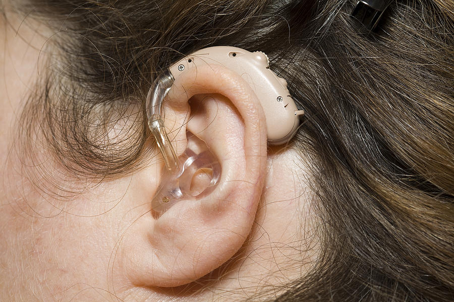 Close up of woman wearing digital hearing aid Photograph by Gannet77