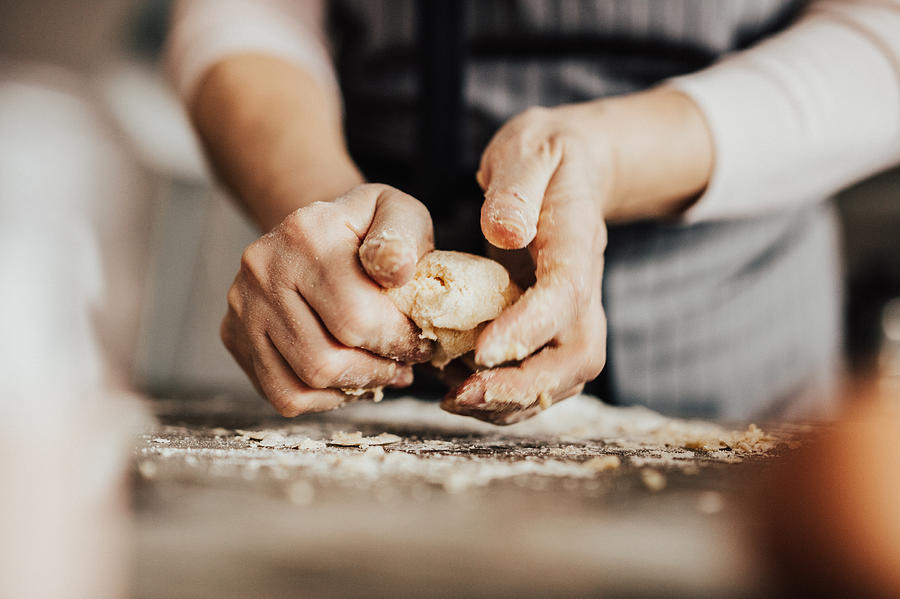 Close-up of womans hands kneading dough Photograph by Anchiy
