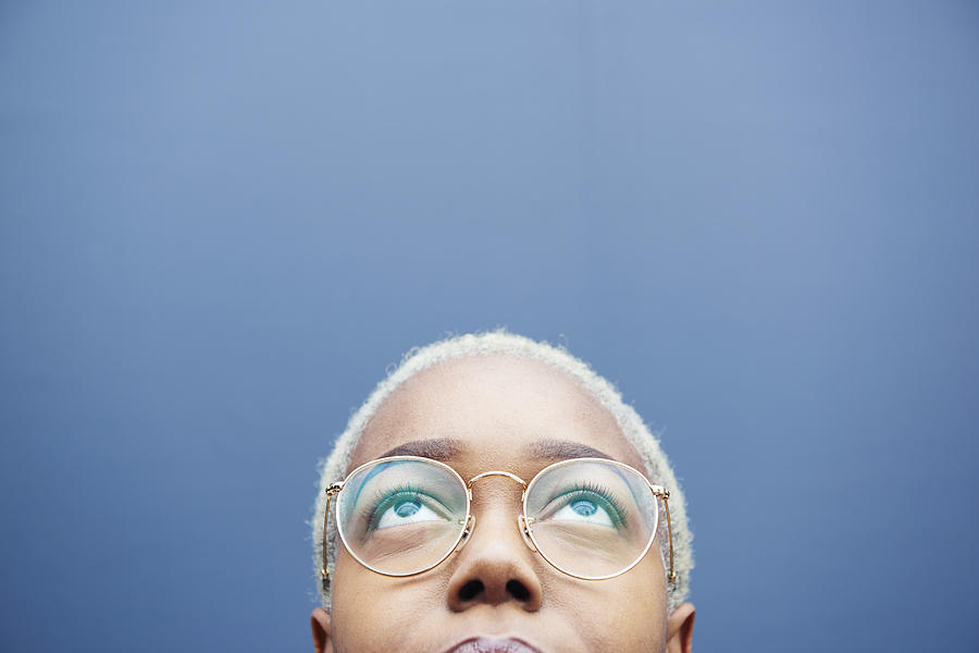 Close up of young woman looking up. Photograph by We Are
