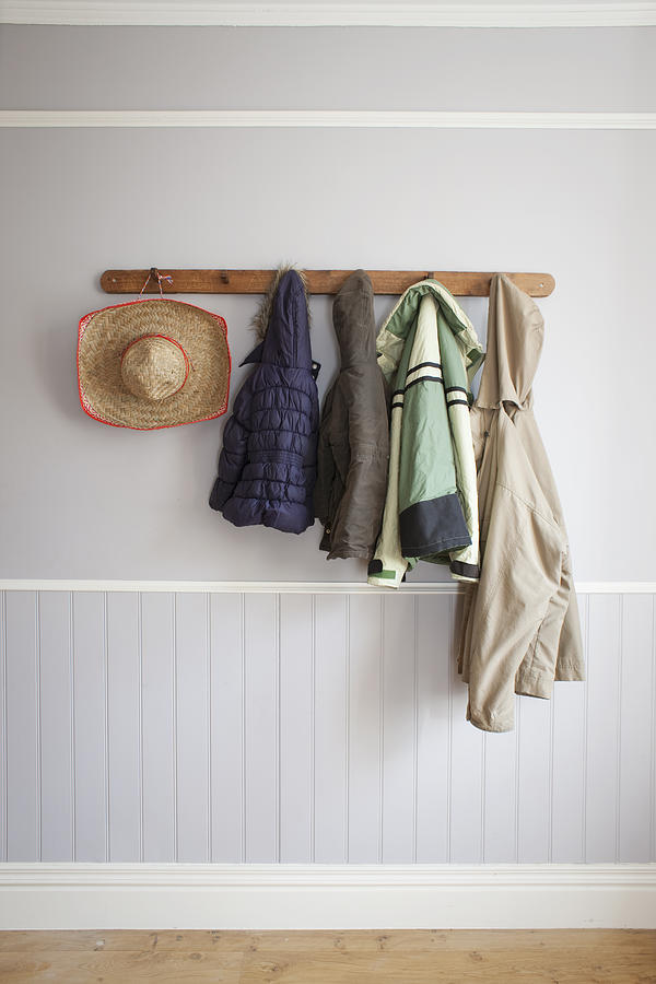 Coats and hat on coat rack Photograph by Ian Nolan