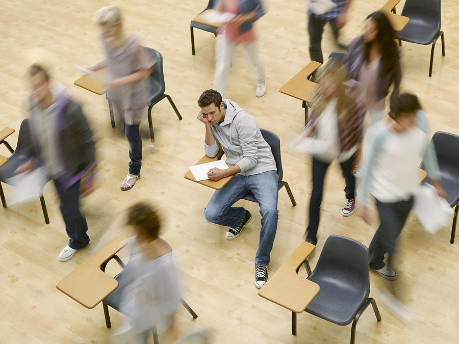 College students moving around man at desk in classroom Photograph by Chris Ryan