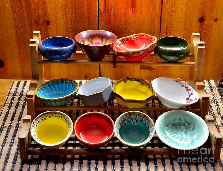Colorful glazed bowls displayed on wooden stand Photograph by Imran Ahmed
