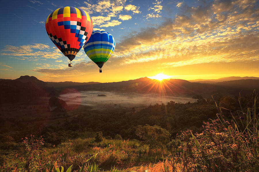Colorful hot air balloon is flying at sunrise Photograph by Busakorn Pongparnit