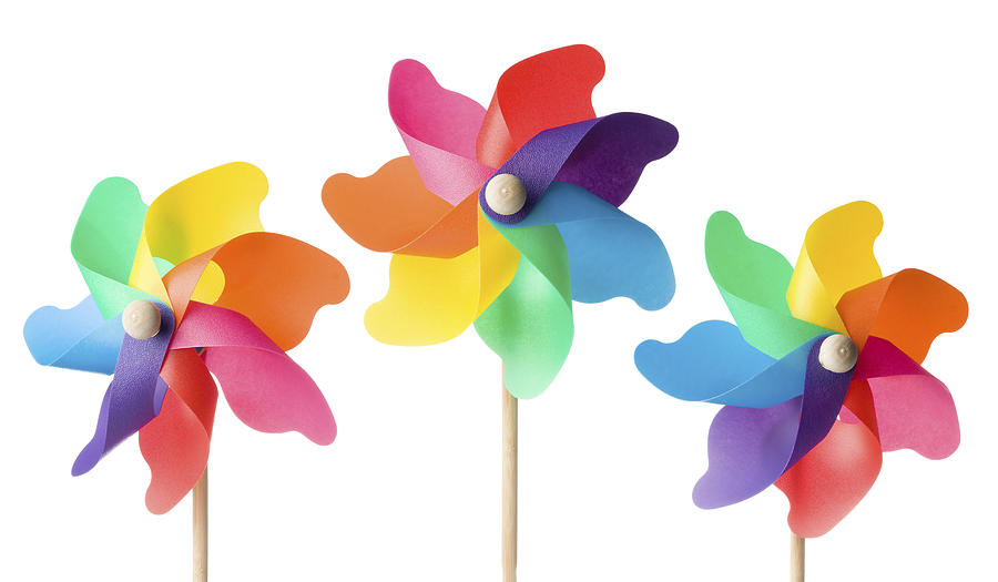 Colorful toy windmills on a white background Photograph by Lleerogers