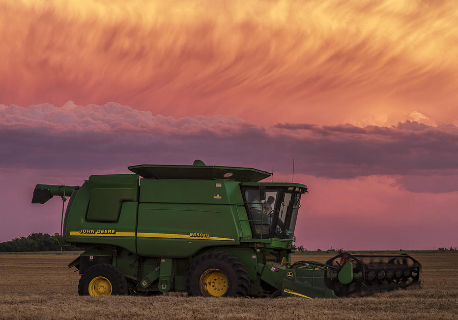 Combine at sunset Photograph by Rob Graham