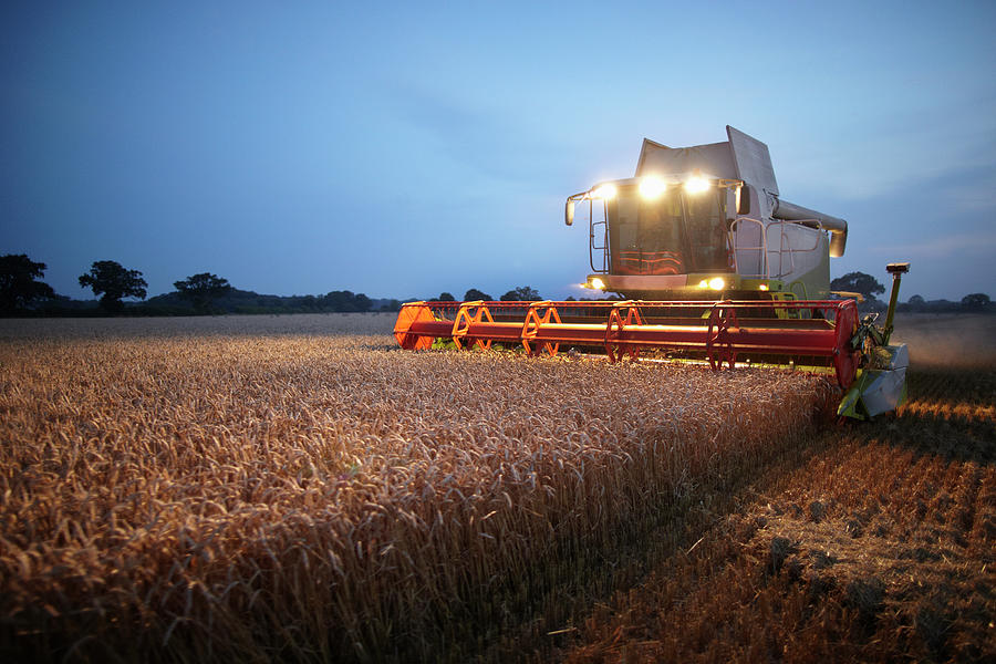 Combine Harvester At Work In Field At Photograph by Gary John Norman