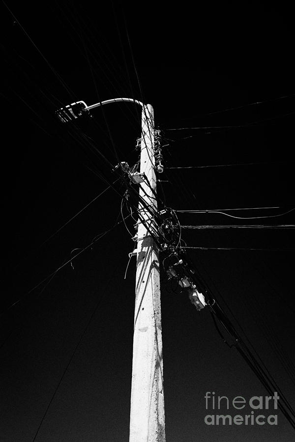 Lamp Photograph - concrete streetlight telegraph pole with electricity and telephone wires Punta Arenas Chile by Joe Fox