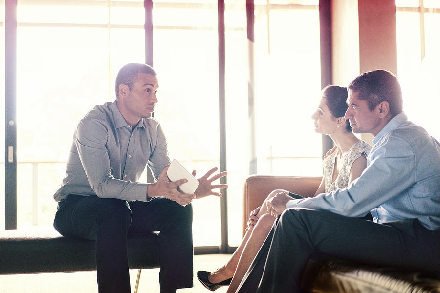 Confident financial planner talking to couple Photograph by Portra