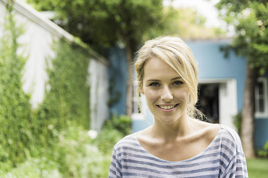 Confident young woman smiling in backyard Photograph by Portra