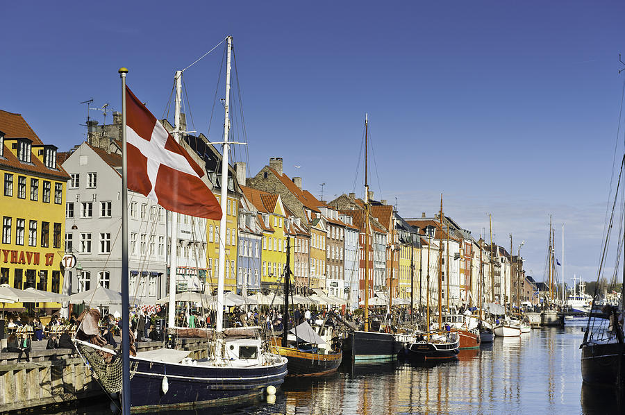 Copenhagen Danish flag flying over Nyhavn colourful harbour Photograph by fotoVoyager