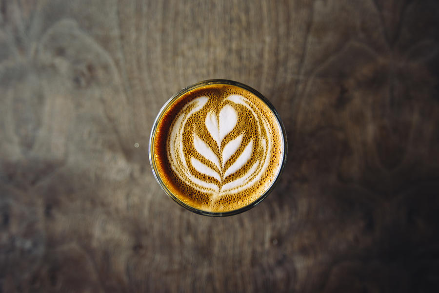 Cortado served in a glass with foam latte art, seen directly from above Photograph by Alexander Spatari