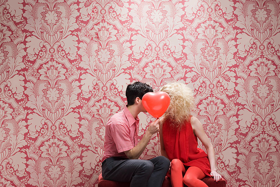 Couple behind heart shaped balloon Photograph by Image Source