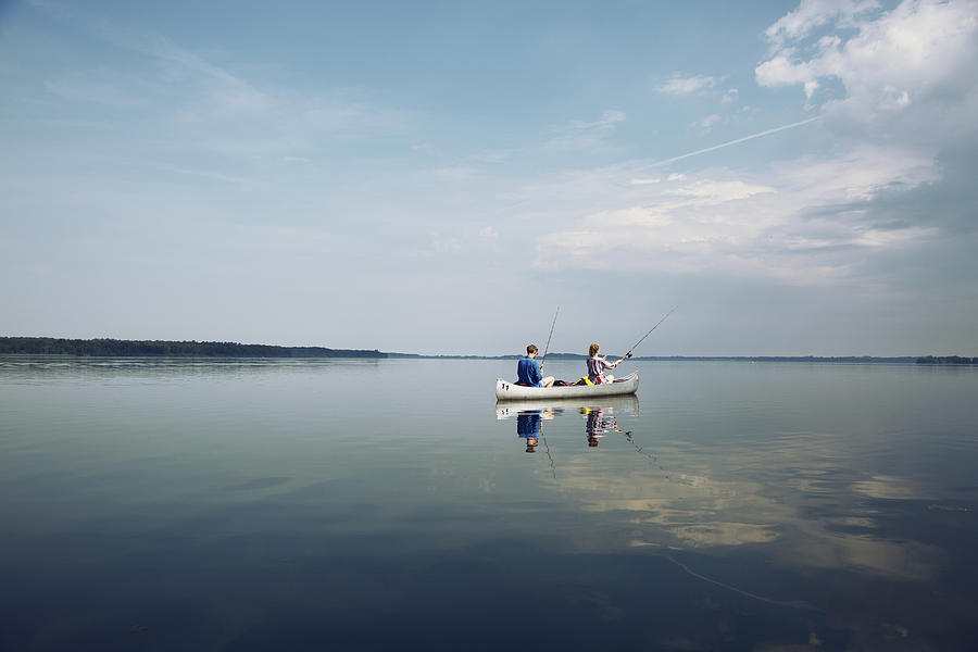 Couple fishing on a quiet lake from a canoe. Photograph by David Trood
