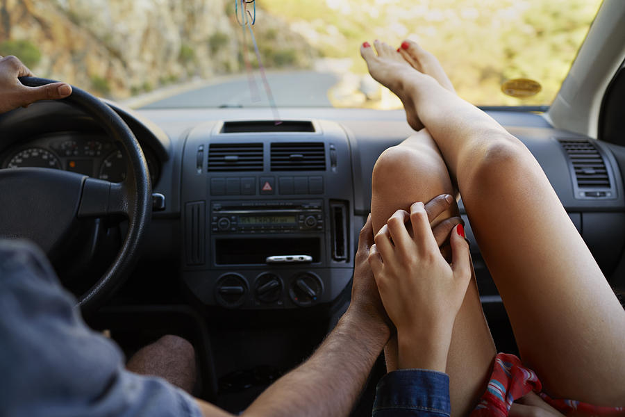 Couple holding hands while driving car Photograph by Klaus Vedfelt