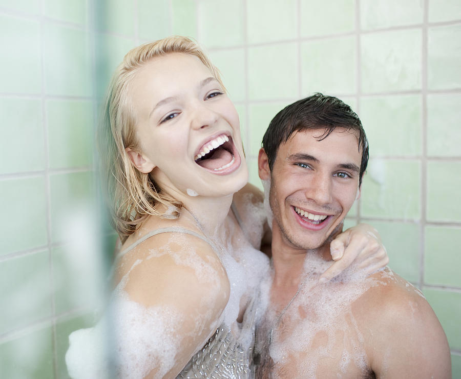 Couple in bathtub covered with soap suds Photograph by Paul Bradbury