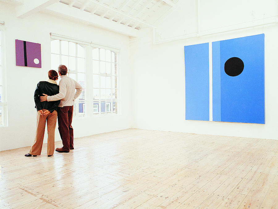 Couple Looking at a Painting in an Art Gallery Photograph by Digital Vision.