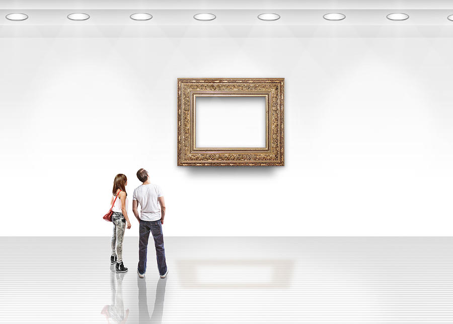 Couple looking at blank art with gold frame Photograph by Paper Boat Creative