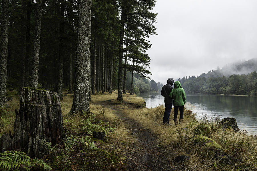 Couple looks out over a misty lake in a forest. Photograph by Tegra Stone Nuess