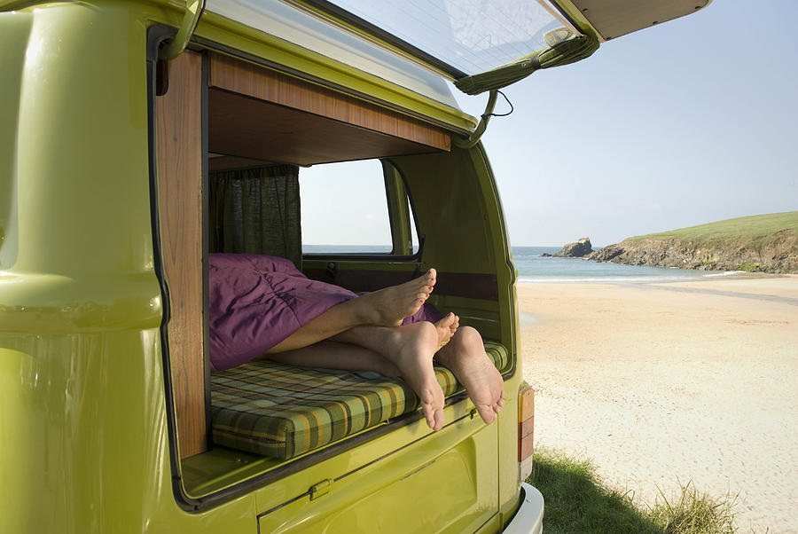 Couple lying in camper van Photograph by Chris Whitehead