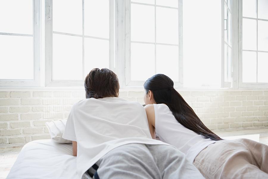 Couple lying on bed Photograph by Image Source
