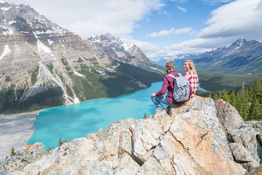 Couple of hikers overlooking mountain lake Photograph by Swissmediavision