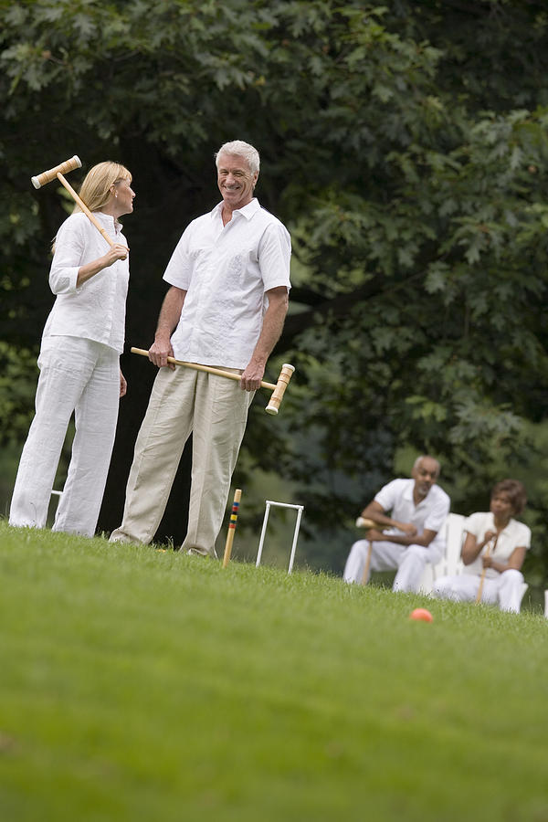 Couple playing croquet Photograph by Comstock Images