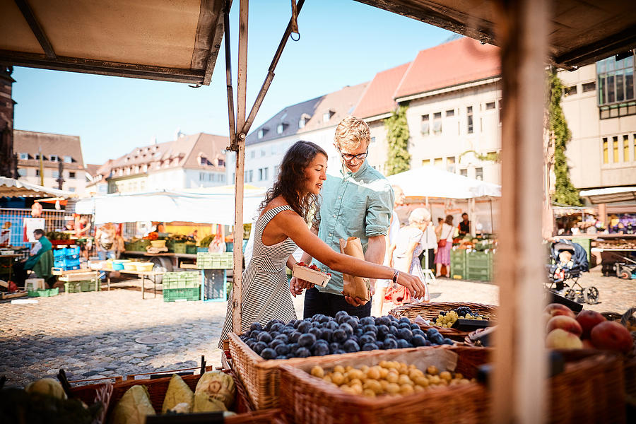 Couple shop at outdoor summer fruit market Photograph by AscentXmedia
