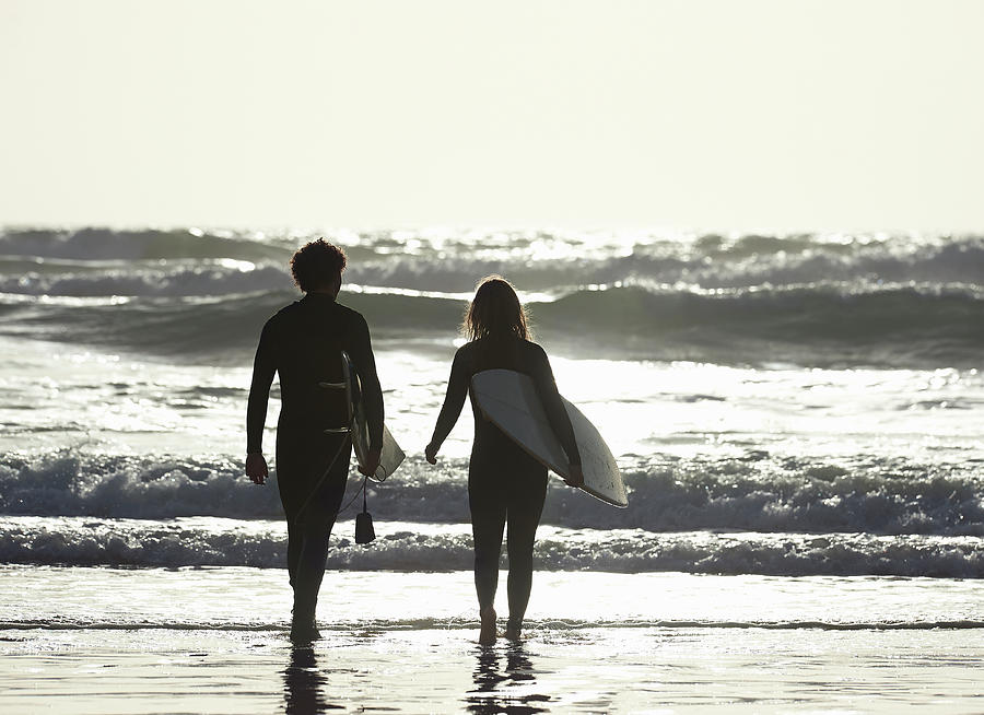 Couple Walking Out To Sea With Photograph by Dougal Waters