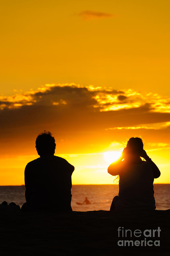 Couple watching the sunset on a beach in Maui Hawaii USA Photograph by Don Landwehrle