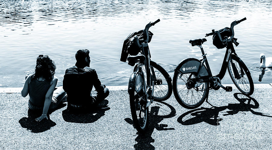 Couple with Barclays London Cycle Hire bicycles resting by the S Photograph by Peter Noyce