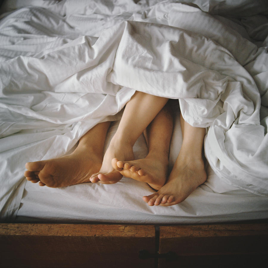 Couples Feet Entangled in Bed Photograph by Danielle D. Hughson