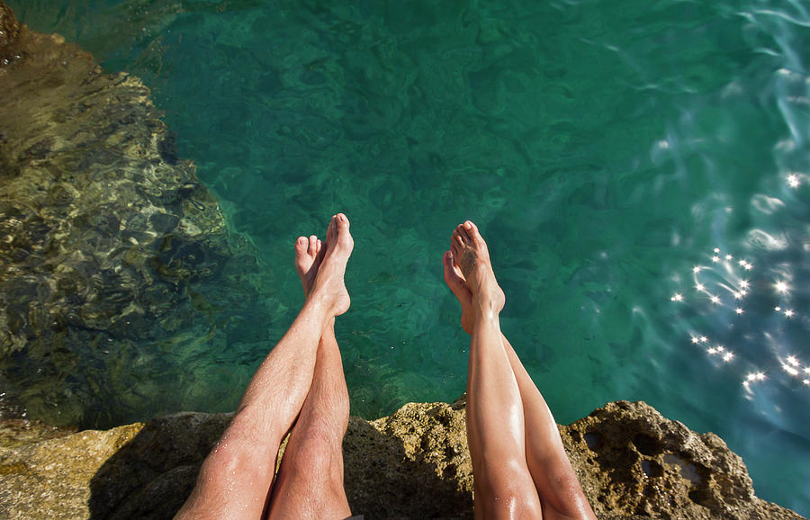 Couples Legs Above Turquoise Ocean Photograph by Picturegarden