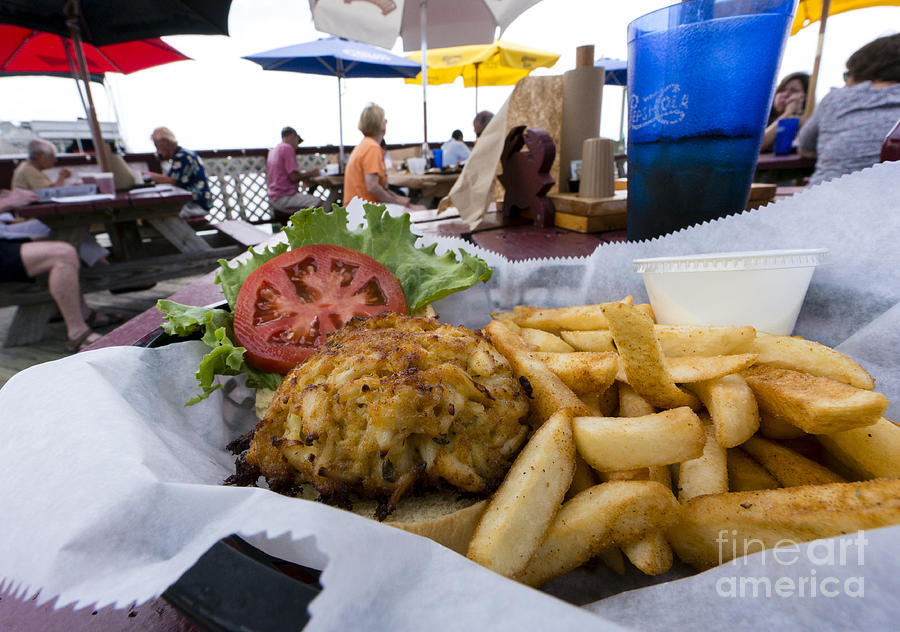 Crabcake sandwich and fries on a seaside deck in Rock Hall Photograph by William Kuta