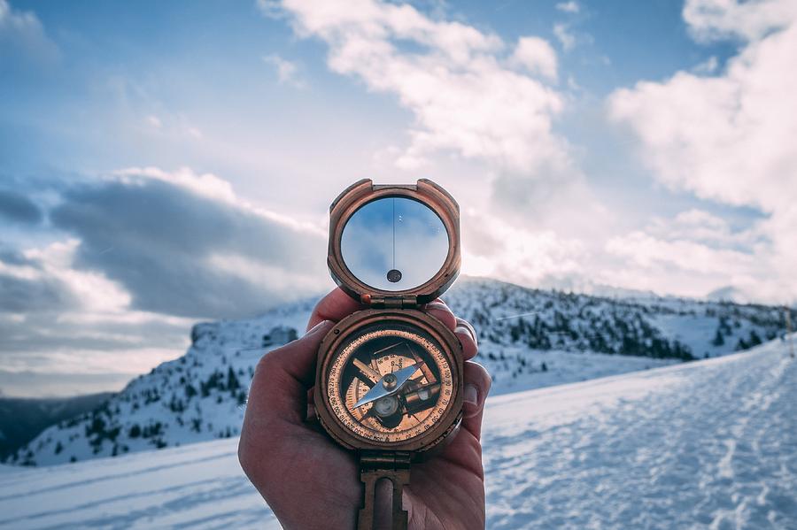 Cropped Hand Holding Navigational Compass Against Sky Photograph by Raphael Fasching / EyeEm