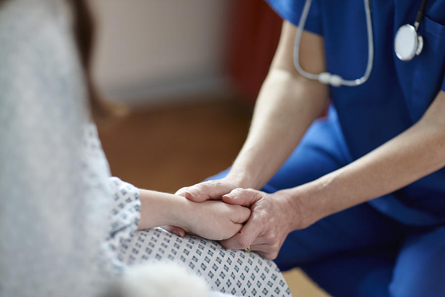 Cropped image of nurse holding patients hand Photograph by Phil Boorman