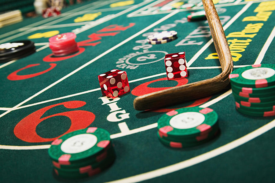 Croupier stick clearing craps table Photograph by Image Source