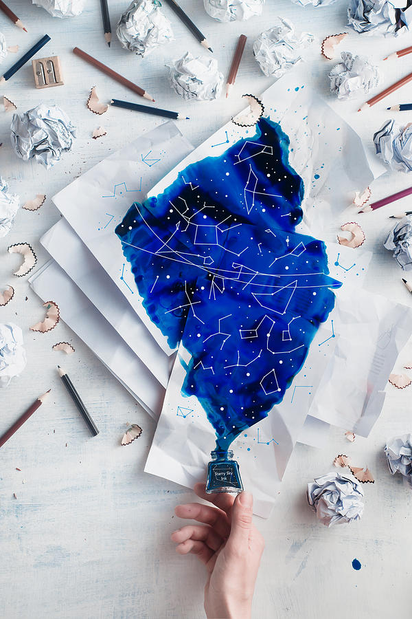 Crumpled paper balls with pencils and papers on a white wooden background with spilled ink forming starry sky with constellations. Writers hand holding an inkwell. Creative writing concept flat lay Photograph by Dina Belenko Photography