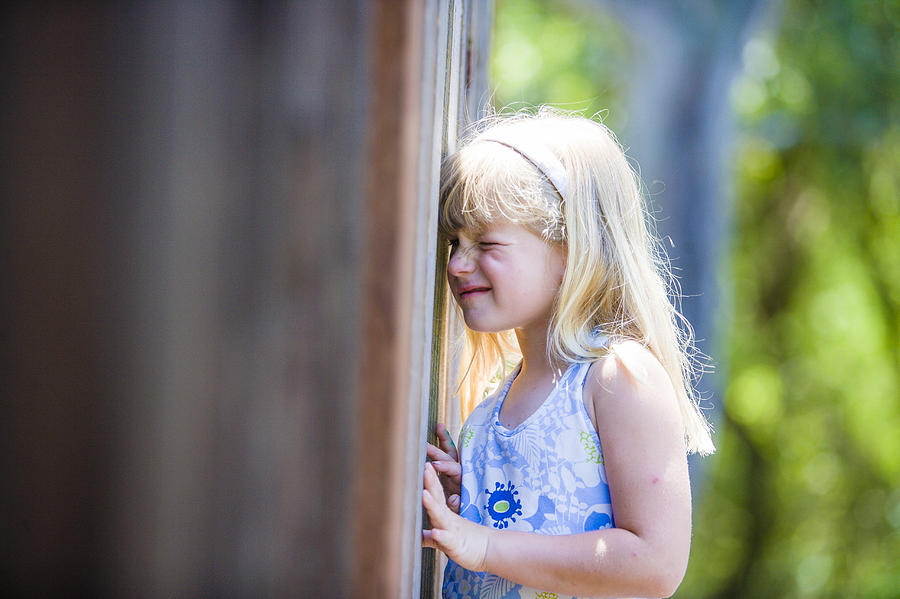 Curious Caucasian girl peeking through wooden fence Photograph by Jed Share/Kaoru Share