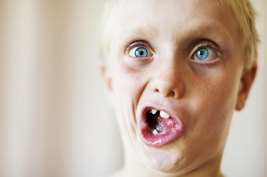 Cute blond 8 year old boy makes zany face Photograph by RapidEye