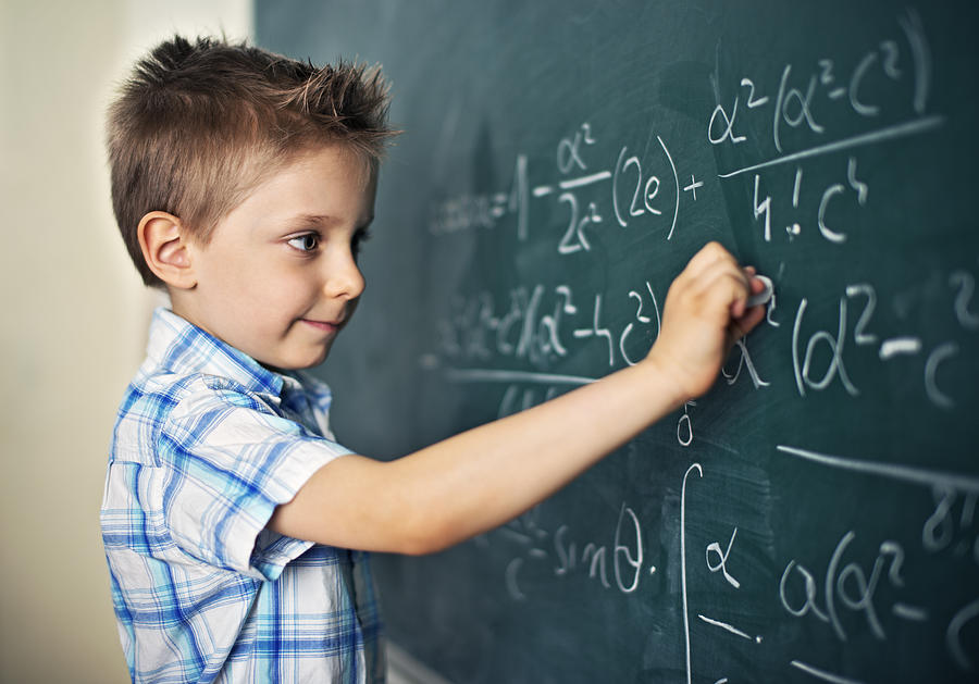Cute little boy solving difficult mathematical problems Photograph by Imgorthand