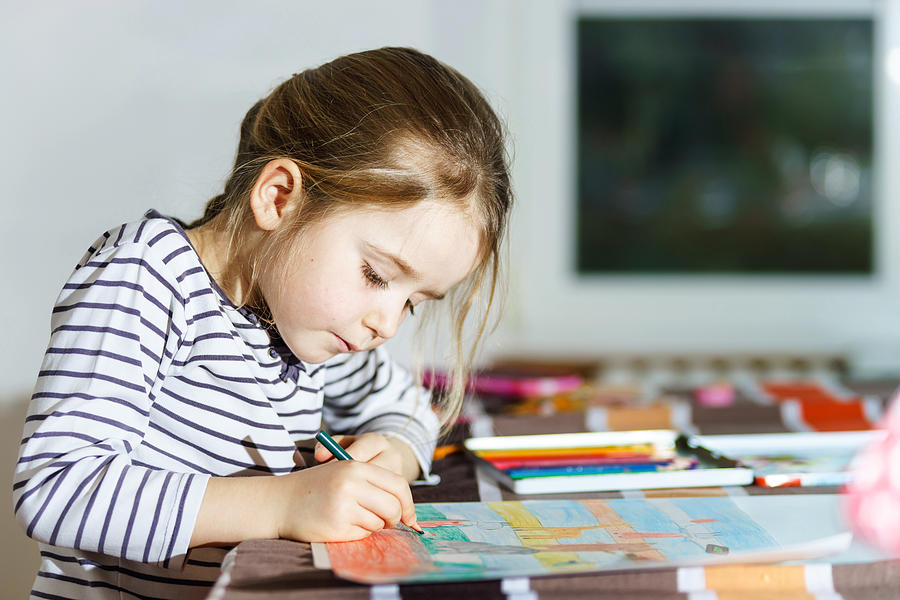 Cute little girl painting by colorful pencil at home Photograph by Alexander Sorokopud