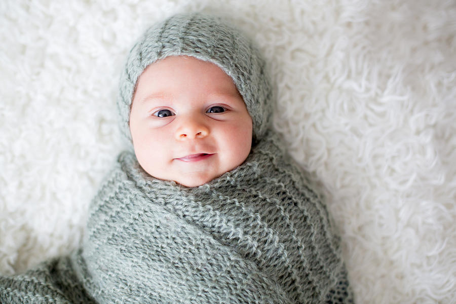Cute newborn baby boy, wrapped in scarf, lying in bed Photograph by Tatyana Tomsickova Photography