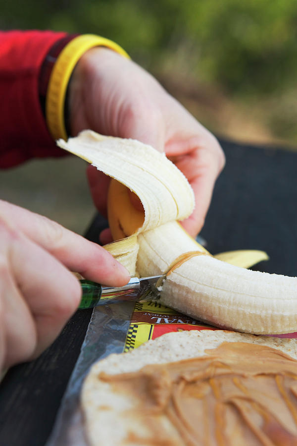 Adult Photograph - Cutting A Peeled Banana by Ron Koeberer
